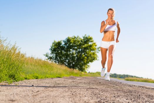 young athletic woman running on the road, exercise outdoors