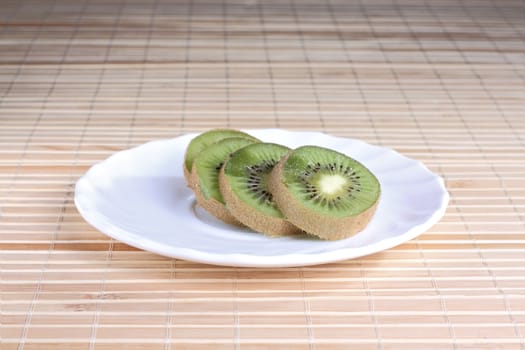 Some kiwi pieces on the white saucer