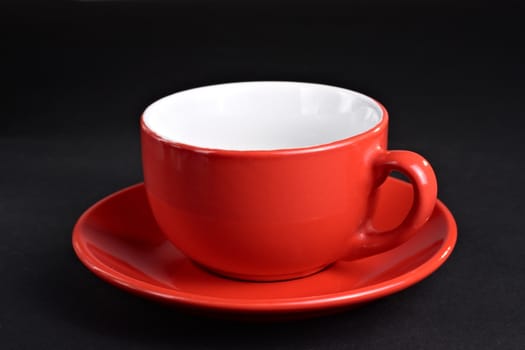 Empty red cup on the plate at the dark background