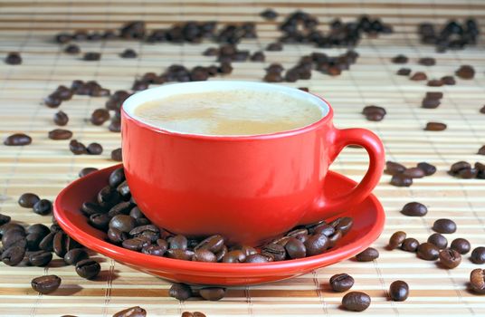 Cup of coffee with roasted beans at wooden background