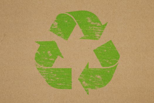 Recycled rubber stamp symbol on brown paper background
