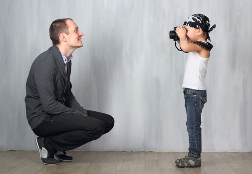 Little photographer takes a photo of a man