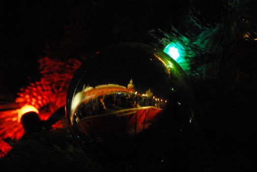Russian Kremlin reflection mirrored in a christmass ball, hanging on tree on the Red Square, at winter evening