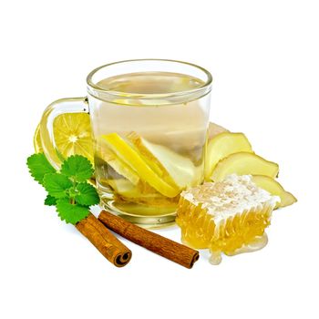 Ginger tea with lemon in a glass mug, mint, cinnamon, ginger root, honeycomb isolated on white background
