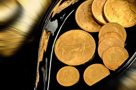 Few old gold coins in black oval box. Swiss, american and russian currency.