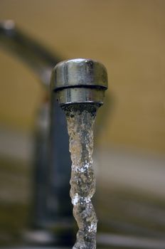 Water tap with flowing water. Selective focus, shallow depth of field