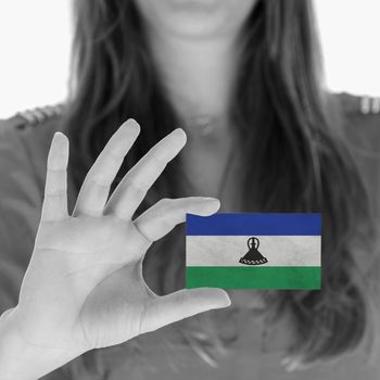 Woman showing a business card, flag of Lesotho