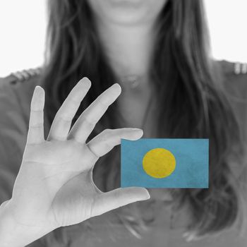 Woman showing a business card, flag of Palau