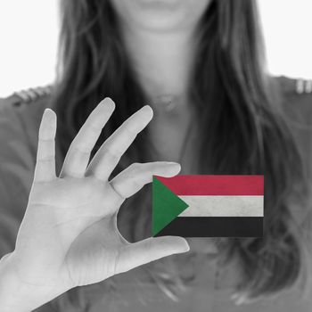 Woman showing a business card, flag of Sudan