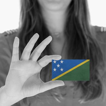 Woman showing a business card, flag of The SOlomon Islands