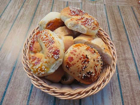 On the table is a basket, which is laid out in the form of various pastries and bread rolls