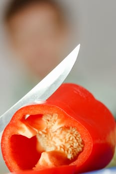 Red pepper and a knife on a cutting board