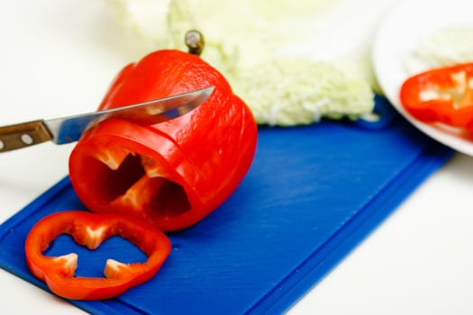 Red pepper and a knife on a cutting board