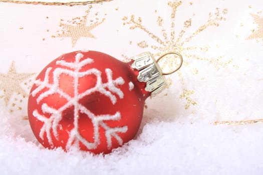 red christmas balls with white pattern on snow 