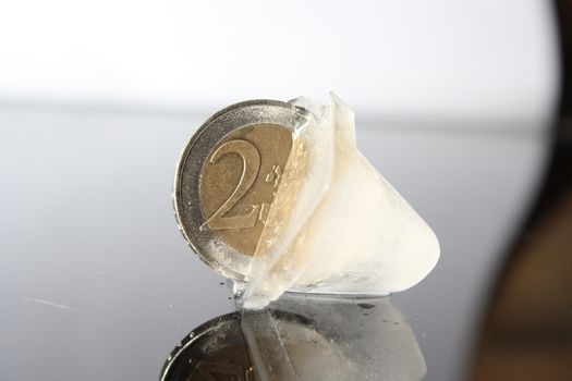 a 2 Euro coin in the ice cube without background 