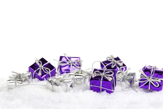 Presents purple and silver on snow with white background 