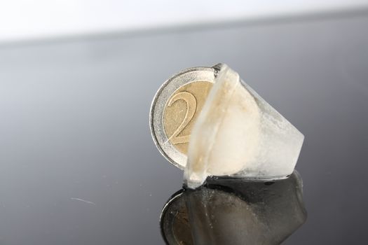 a 2 Euro coin in the ice cube without background