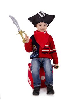 Small boy dressed like pirate holding toy sword over white