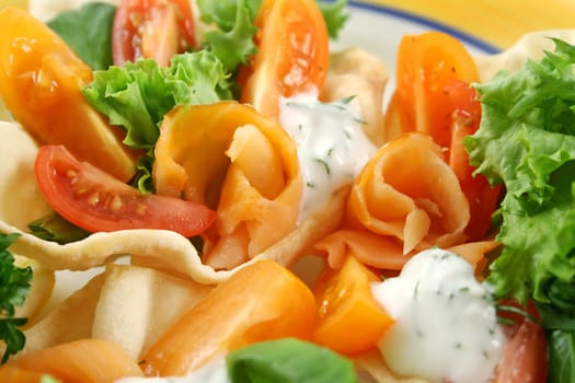 Colorful salmon papadums with a red and yellow tomato salad with yogurt and dill.