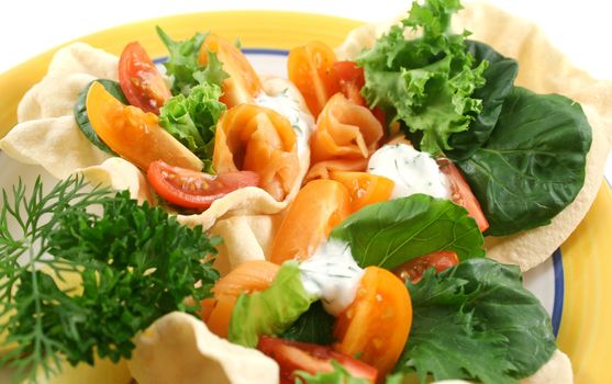 Colorful salmon pappadums with a red and yellow tomato salad with dill and lemon.