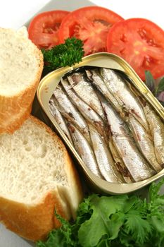Sardines with bread, red onion, tomato and lettuce.