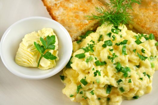 Butter with toast and scrambled eggs.