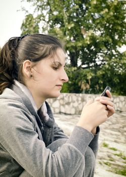 Sad woman sending a message by mobile phone