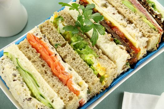 Freshly prepared assorted sandwiches cut without crusts.