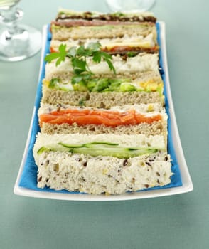 Freshly prepared assorted sandwiches cut without crusts.