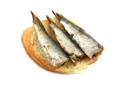 Buffet snack of three sardines on a slice of French bread.