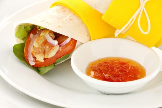 Delicious spicy chicken wraps in tortillas with sweet chilli sauce ready to serve.
