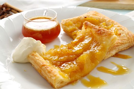 Delicious spiced pineapple galette served with cream and pineapple syrup.