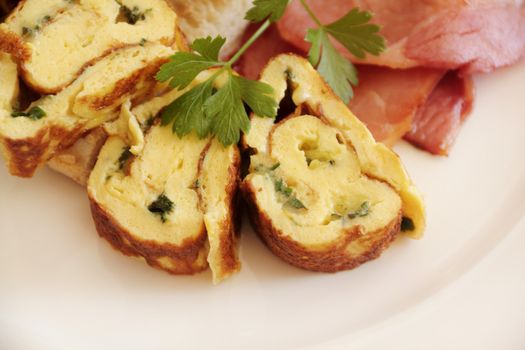 Delicious sliced rolled omelette with bacon and Turkish bread with parsley.
