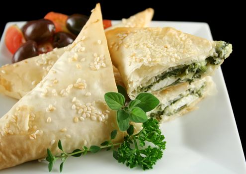 Spinach and feta cheese triangles with garnish.
