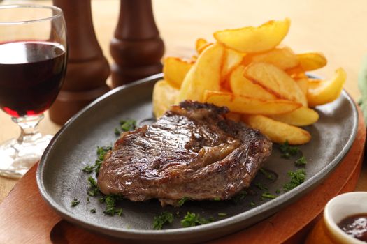 Grilled rib fillet steak with fried chips ready to serve.