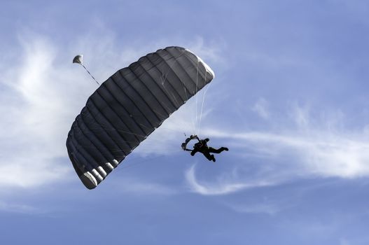 Skydiver maneuvers at low altitude as he approaches the landing zone.