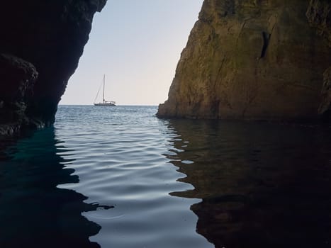 Sailing boat view from the cave in the island     