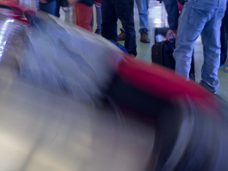 Airport baggage claim, passengers wait for their luggage on conveyor belt after flight landing