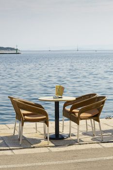 Empty table and four chairs in the port of Vis, Croatia, Adriatic sea 