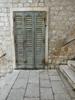 Old green shutter door between stairs in old town Sibenik, Croatia         
