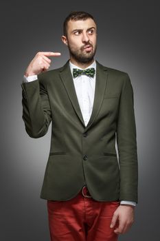 young man in a green suit, pointing at the right