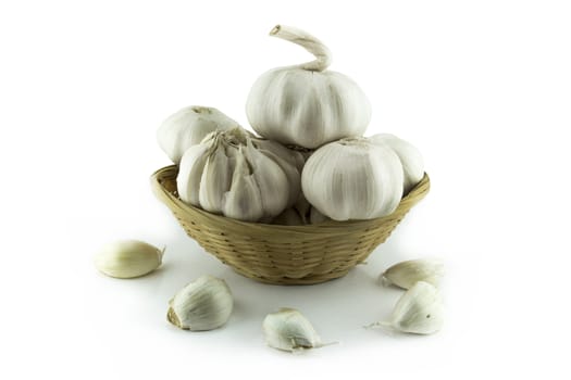 Garlic and garlic bulb in straw dish .