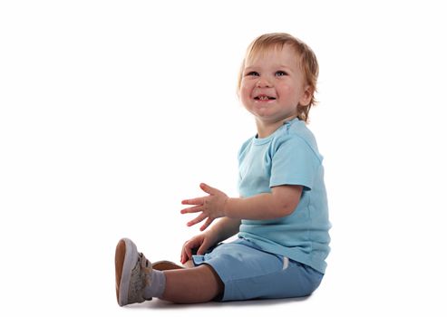 Little boy sitting and smiling isolated on the white