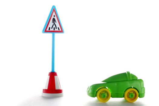 Green car behind Pedestrian crossing road sign on white background
