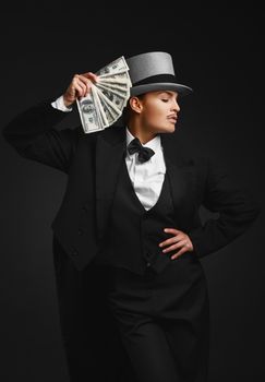 The girl in the image of the gangster with dollars in their hands, on the black background