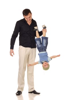 Man holds little boy upside down at white background