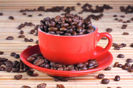 Cup on the saucer full of coffee beans