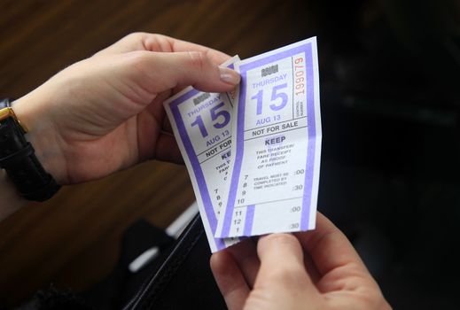 Two bus ticket in female hands