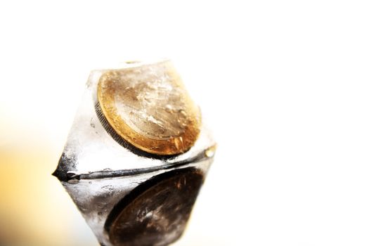 a 2 Euro coin in the ice cube without background