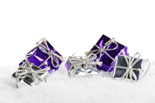 Presents purple and silver on artificial snow with white background 